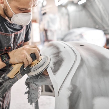 Worker sanding a car part with Reactec watch